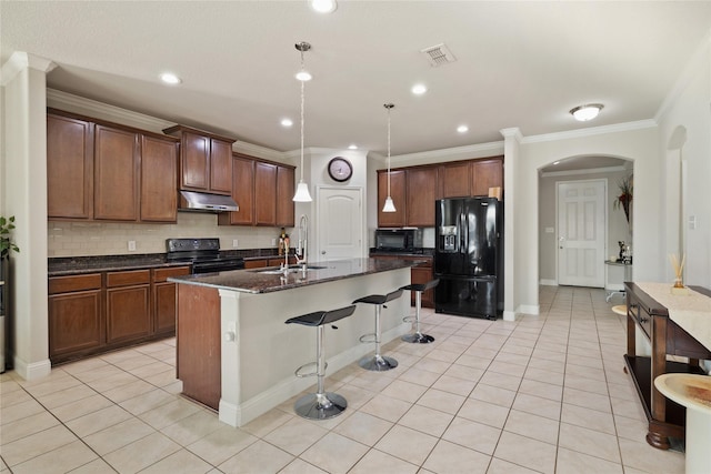 kitchen featuring black appliances, a center island with sink, visible vents, under cabinet range hood, and a sink