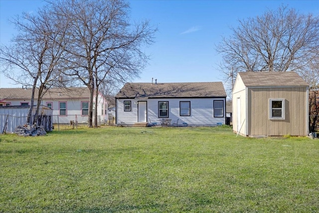 back of house with a yard, an outdoor structure, fence, and a storage unit