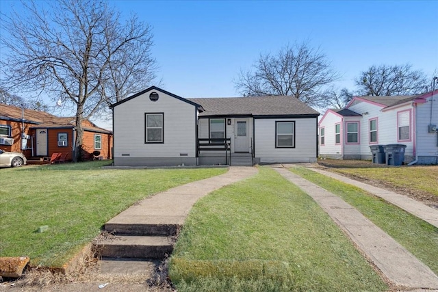 view of front of home with crawl space, roof with shingles, and a front yard