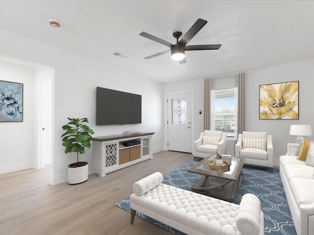 living area with ceiling fan, wood finished floors, visible vents, and baseboards