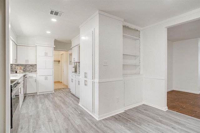 kitchen with electric range, visible vents, light countertops, light wood-style floors, and white cabinetry