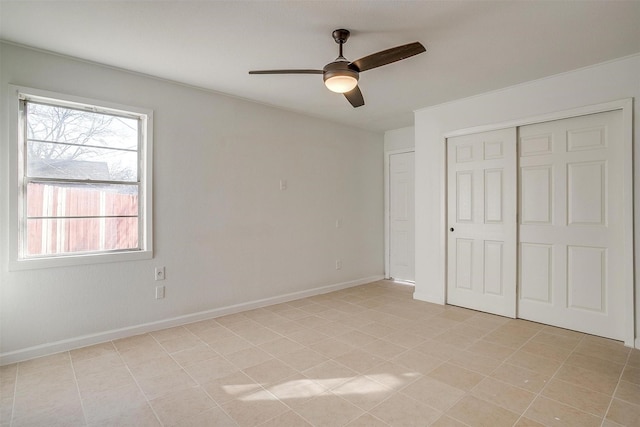 unfurnished bedroom featuring ceiling fan, baseboards, and a closet