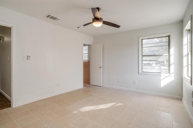 spare room with plenty of natural light, visible vents, ceiling fan, and baseboards