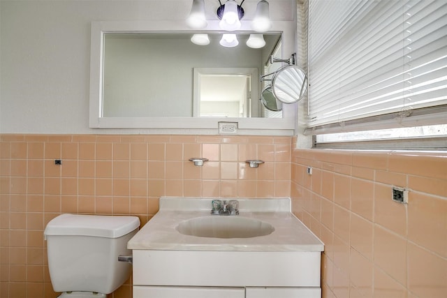 half bath with toilet, tile walls, and vanity