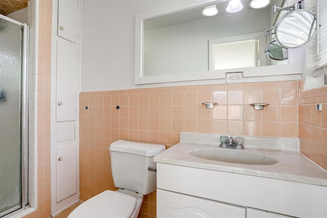 bathroom featuring tile walls, toilet, vanity, and a shower stall