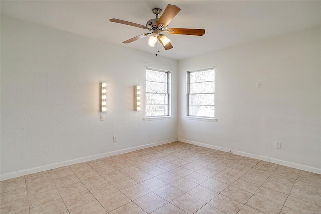 empty room featuring ceiling fan and baseboards