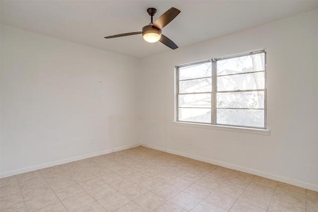 spare room featuring a ceiling fan and baseboards