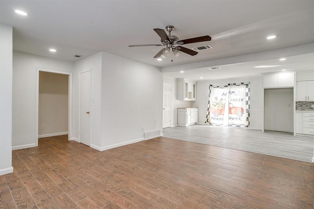 unfurnished living room with light wood-type flooring, visible vents, and recessed lighting