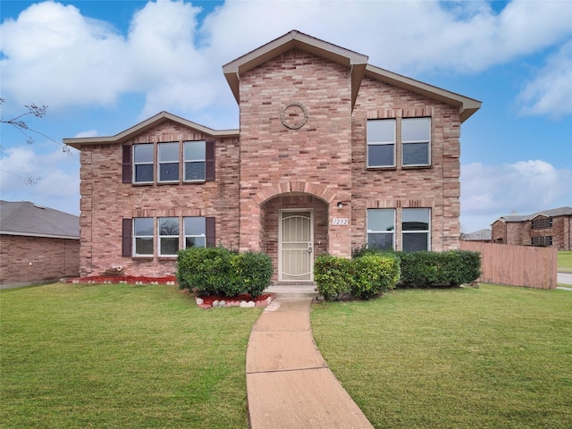 view of front of home featuring brick siding, a front yard, and fence