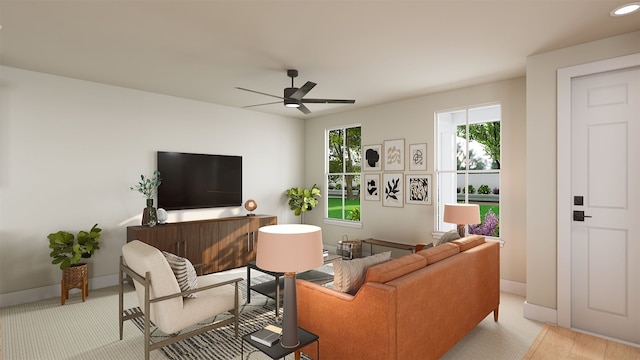 living room with a wealth of natural light, ceiling fan, and baseboards