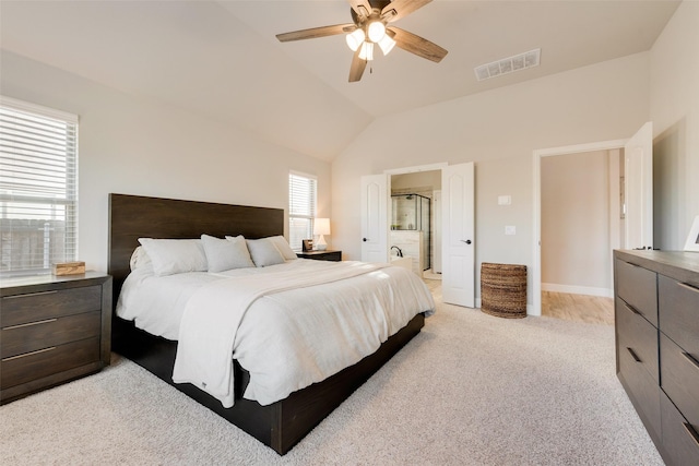 bedroom featuring vaulted ceiling, multiple windows, ensuite bath, and visible vents