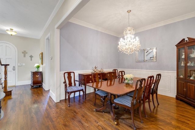 dining room with wainscoting, stairway, dark wood-type flooring, an inviting chandelier, and crown molding