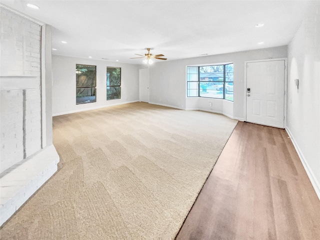 unfurnished living room with light carpet, recessed lighting, a ceiling fan, and baseboards