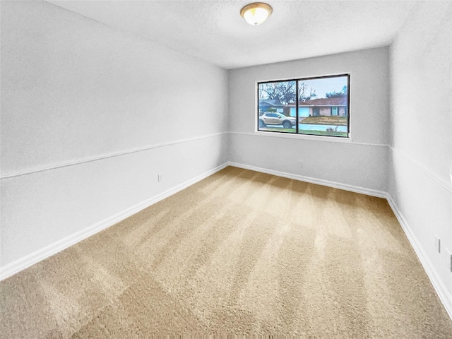 unfurnished room with carpet, a textured ceiling, and baseboards