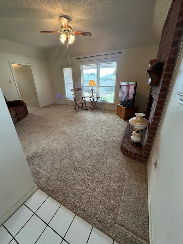 carpeted living area with a textured ceiling and ceiling fan