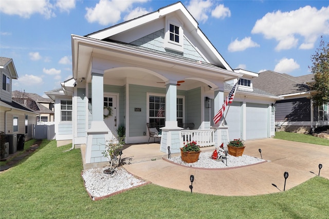 view of front of property with covered porch, concrete driveway, a front yard, a garage, and ceiling fan