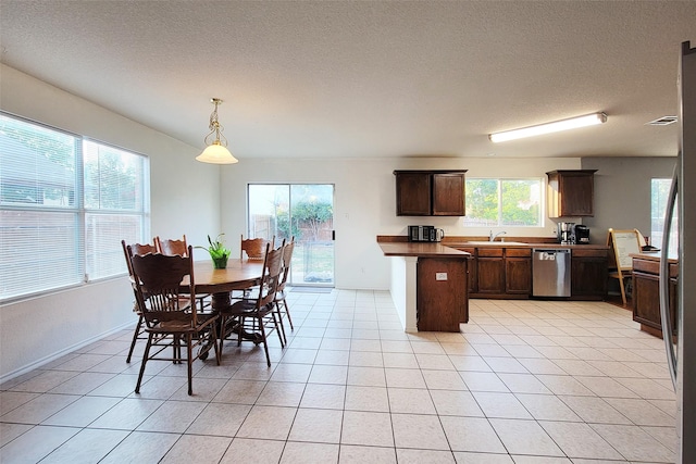 dining space with light tile patterned floors, baseboards, and a textured ceiling