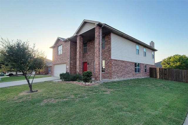 view of home's exterior with a garage, driveway, a lawn, fence, and brick siding