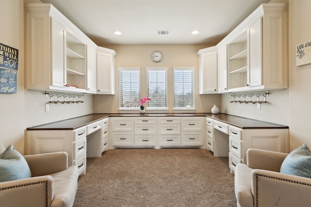 kitchen with built in desk, open shelves, dark countertops, recessed lighting, and light colored carpet