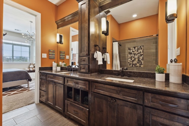 full bathroom with double vanity, a shower with curtain, a sink, and ensuite bathroom