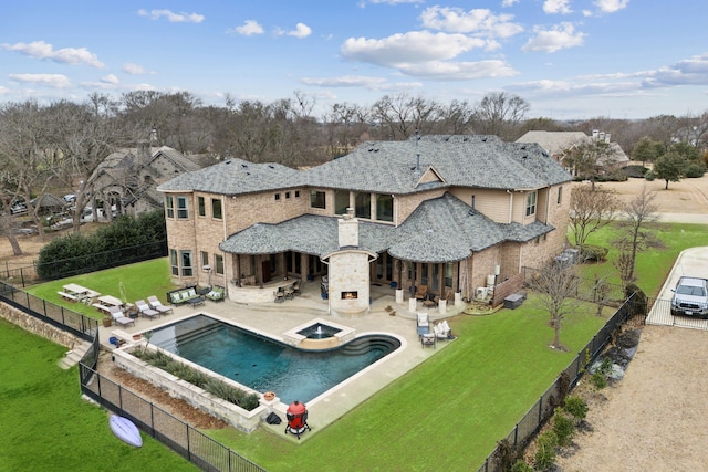 rear view of house featuring dirt driveway, a fenced backyard, a yard, a patio area, and a multi sided fireplace