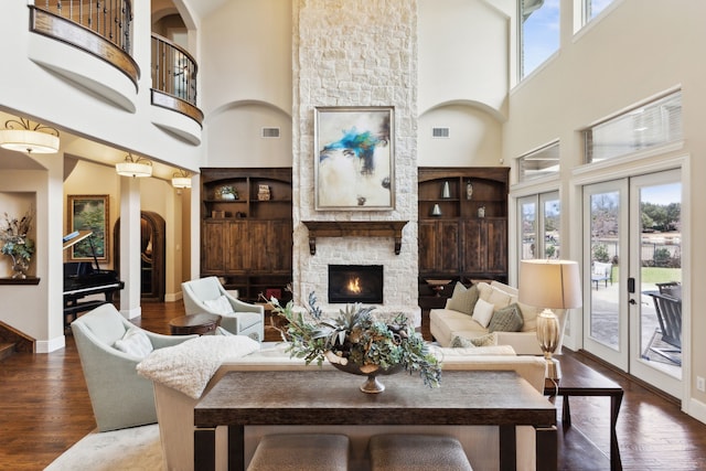 living area with french doors, visible vents, plenty of natural light, and wood finished floors