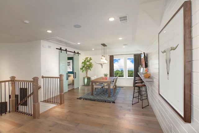 1909 Paxton Pass, Mckinney, TX 75071 - dining room featuring a barn door, wood finished floors, attic access, and recessed lighting
