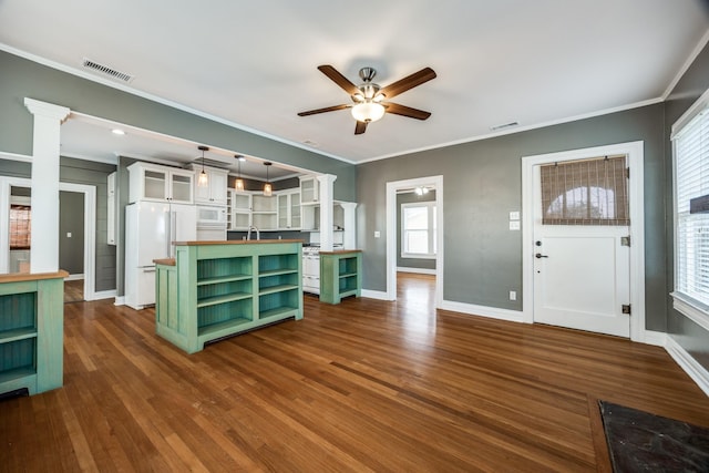 unfurnished living room with dark wood-style floors, baseboards, visible vents, and crown molding