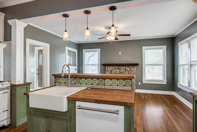 kitchen with plenty of natural light, ornamental molding, green cabinets, and a sink