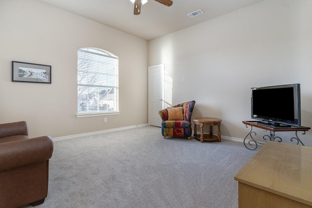 sitting room featuring light carpet, baseboards, visible vents, and a ceiling fan