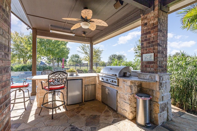 view of patio / terrace featuring outdoor dry bar, area for grilling, a ceiling fan, a grill, and fence