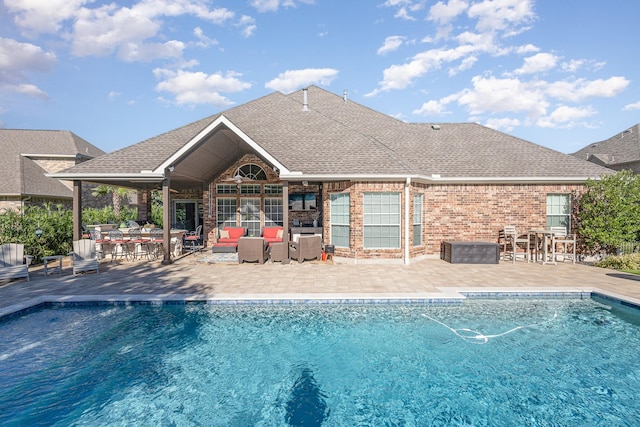 outdoor pool with a patio, an outdoor living space, and exterior bar