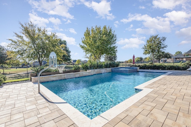 view of swimming pool with a patio area, a pool with connected hot tub, and fence