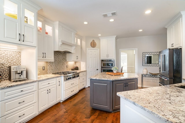 kitchen featuring light stone counters, visible vents, white cabinets, appliances with stainless steel finishes, and gray cabinets