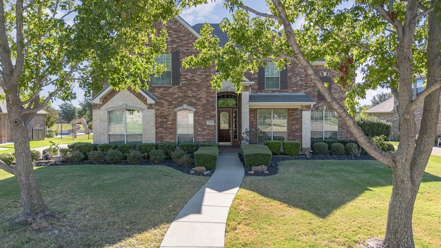 traditional-style house featuring brick siding and a front yard