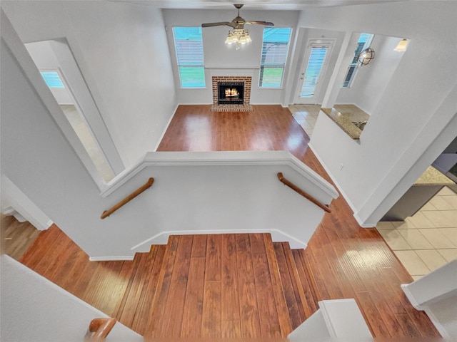 1825 Heron Dr, Aubrey, TX 76227 - unfurnished living room featuring wood finished floors, ceiling fan, a fireplace, and stairway