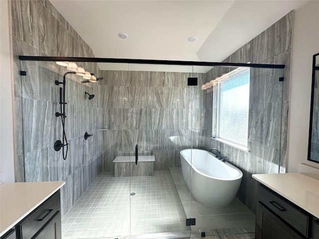 full bath featuring tile walls, vanity, a freestanding bath, a shower stall, and tile patterned floors