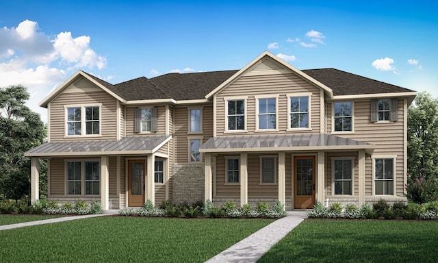 view of front of home with a standing seam roof, covered porch, metal roof, and a front lawn