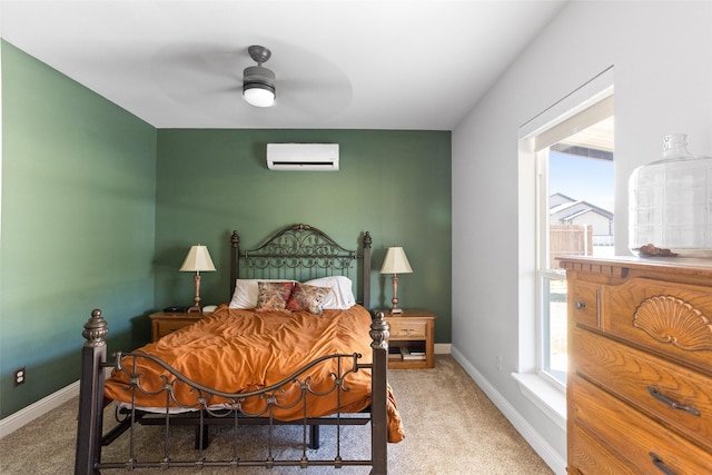 carpeted bedroom with ceiling fan, a wall mounted air conditioner, and baseboards