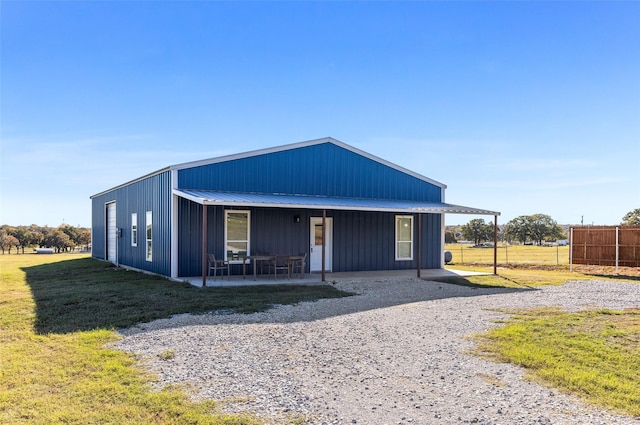 view of front of property featuring fence, a front lawn, and metal roof