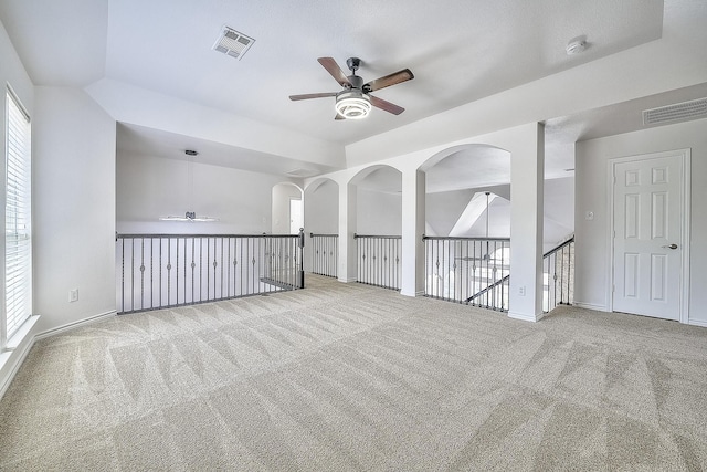 spare room featuring light colored carpet, visible vents, and ceiling fan