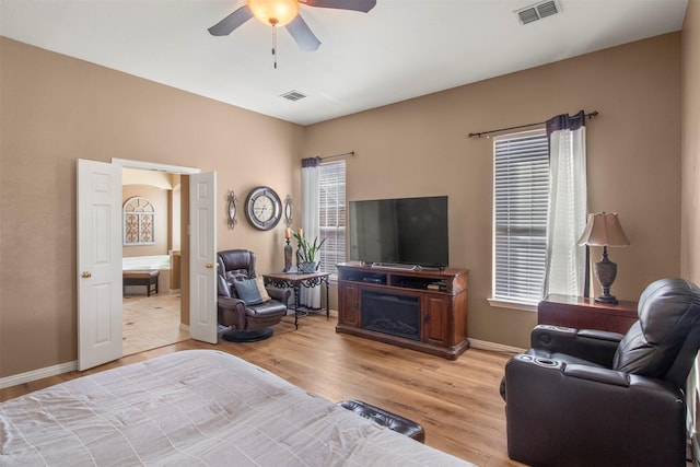 bedroom featuring light wood finished floors, baseboards, visible vents, and a ceiling fan