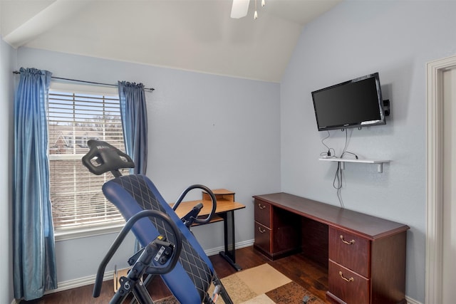 exercise room with baseboards, a ceiling fan, vaulted ceiling, and wood finished floors