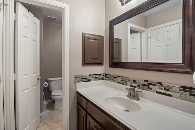 bathroom featuring toilet, tasteful backsplash, and vanity