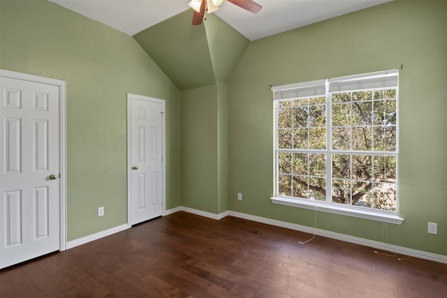 unfurnished bedroom with lofted ceiling, dark wood-type flooring, a ceiling fan, and baseboards