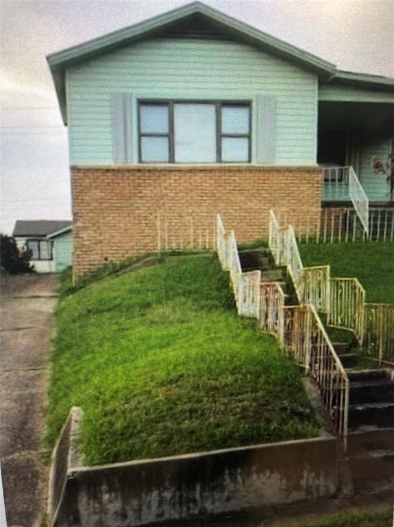 view of front of property featuring stairs and brick siding