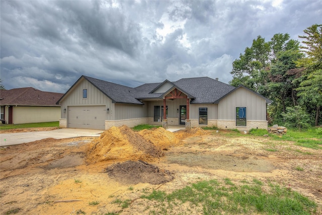 modern farmhouse style home featuring board and batten siding, driveway, a shingled roof, and an attached garage