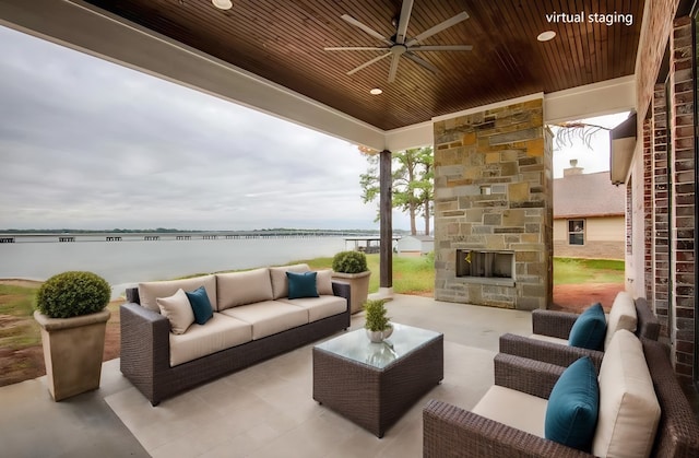 view of patio featuring a water view, ceiling fan, and an outdoor living space with a fireplace