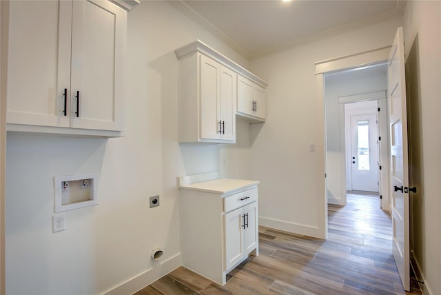 washroom featuring washer hookup, crown molding, light wood finished floors, cabinet space, and hookup for an electric dryer