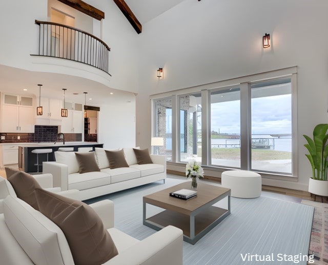 living area featuring a water view, light wood finished floors, and a high ceiling